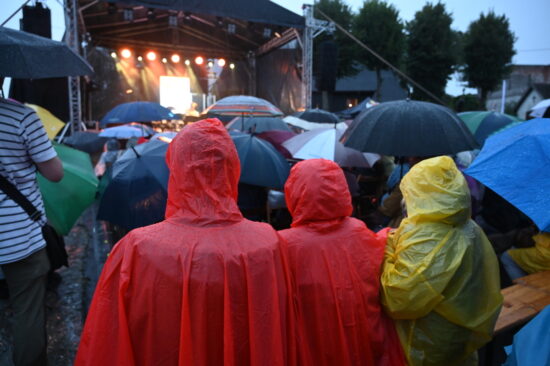 Publiczność w deszczowych pelerynach