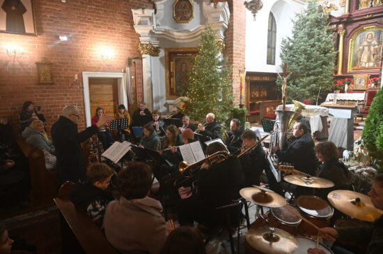 Orkiestra dęta przed ołtarzem w kościele.