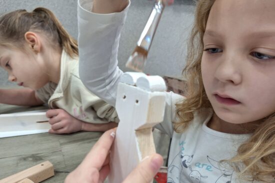 Dziewczynka maluje drewnianego misia