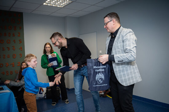 Dyrektor Centrum Kultury i Sportu wręczający nagrodę najmłodszemu szachiście.