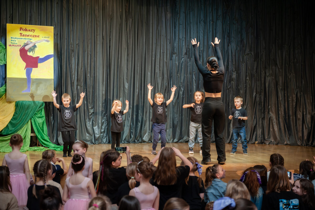 Grupa dzieci tańczy na scenie.