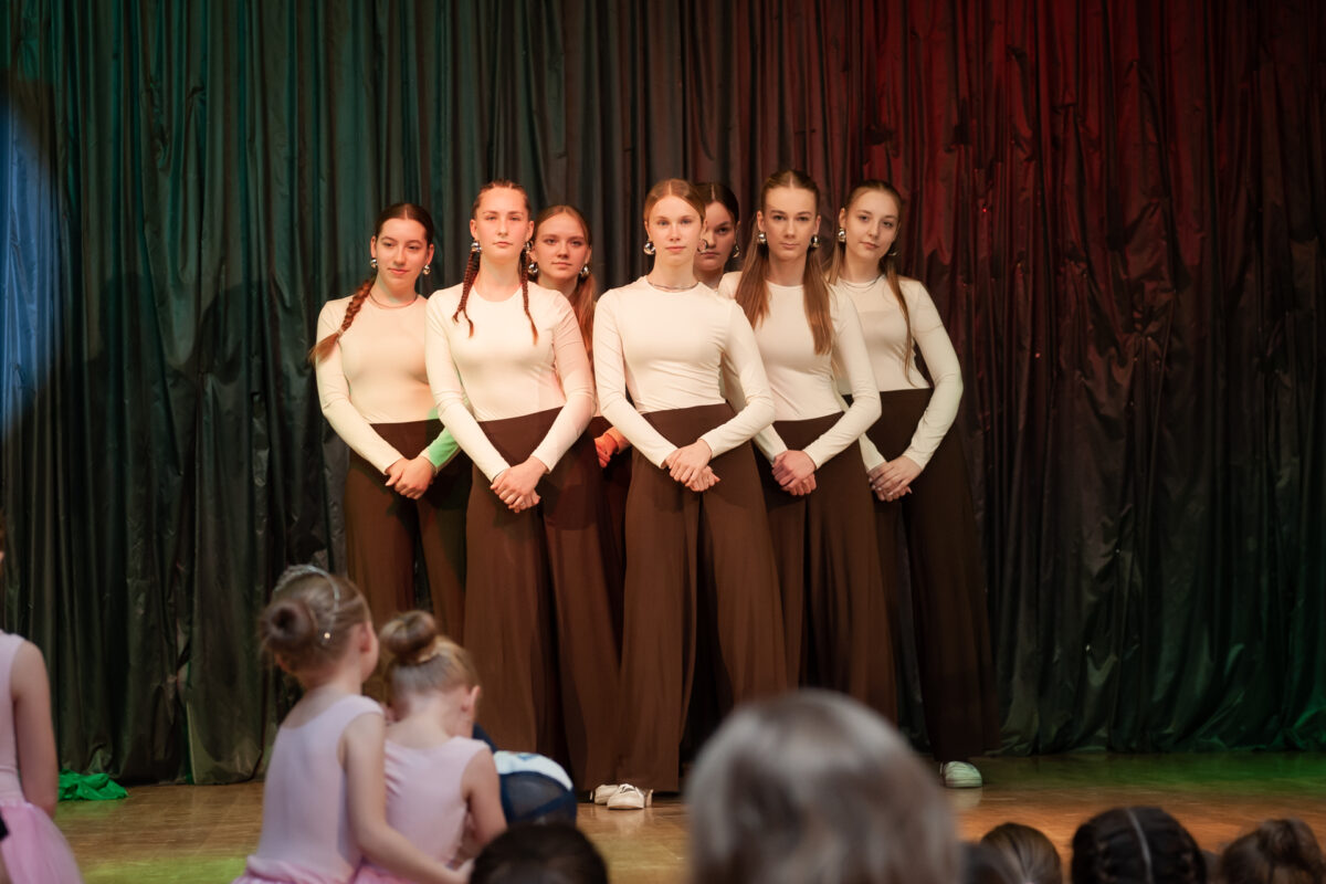 Grupa dziewczyn tańczy na scenie.