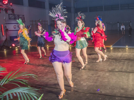 Grupa tańczących kobiet w kolorowych strojach.